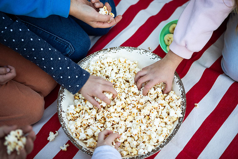 National Popcorn Month photo with kids eating popcorn from a big bowl
