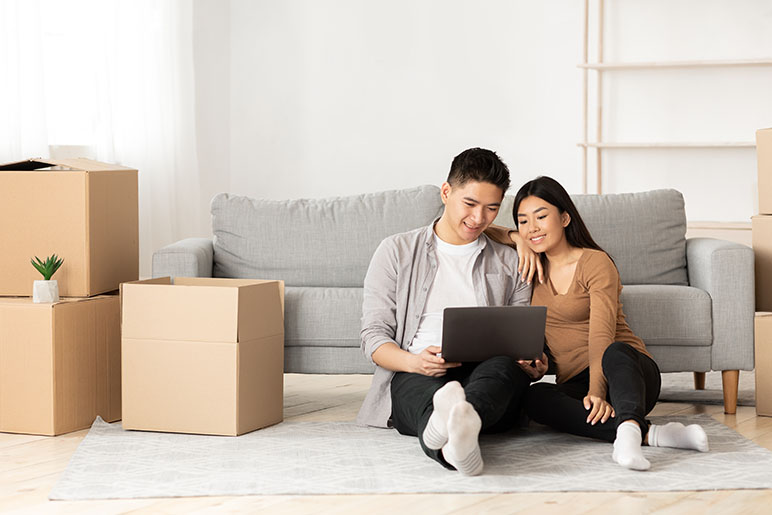 A couple who just moved into their first home looking on their laptop for purchasing home insurance 