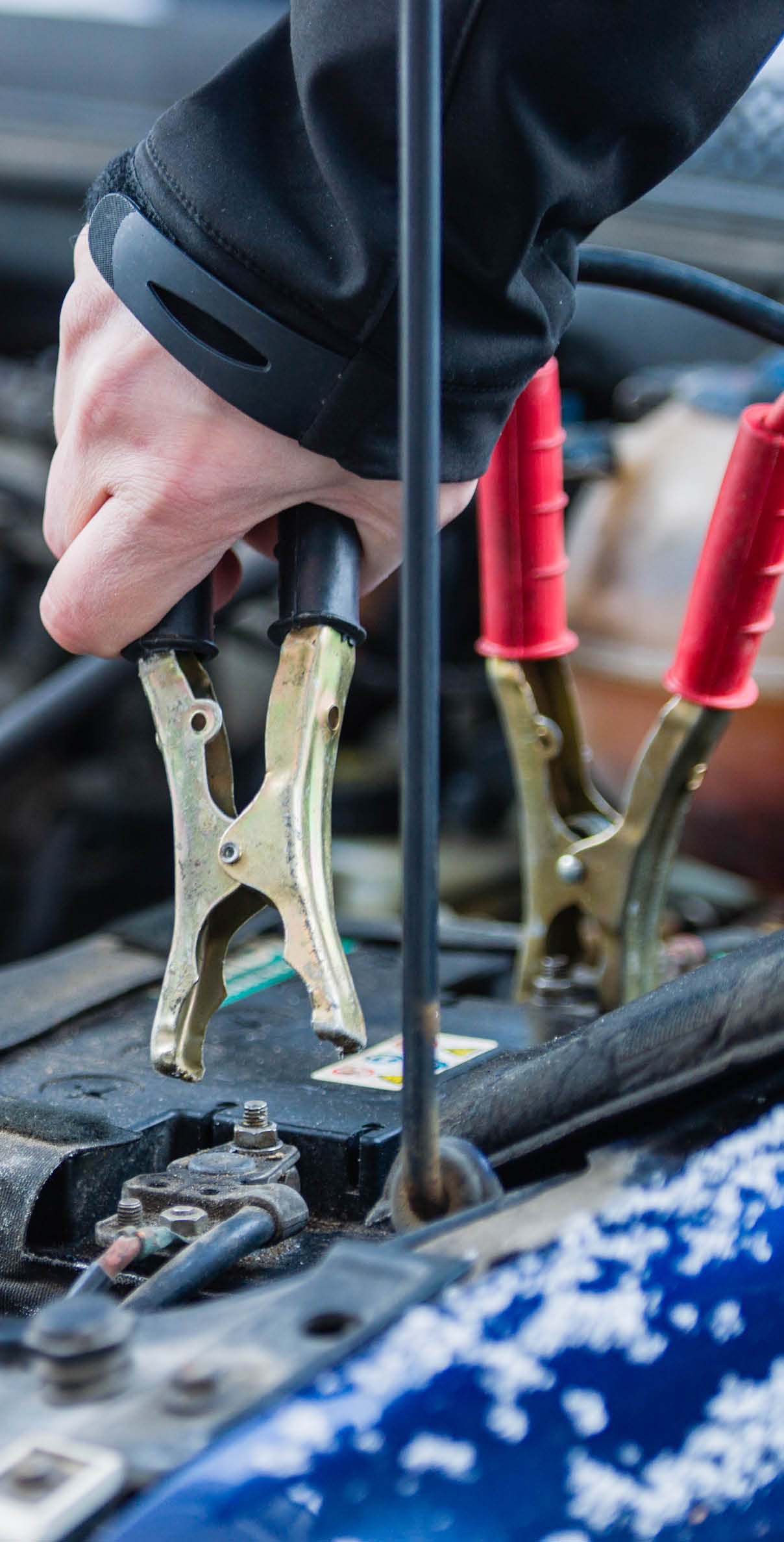 Jumpstarting a car battery in cold weather. 
