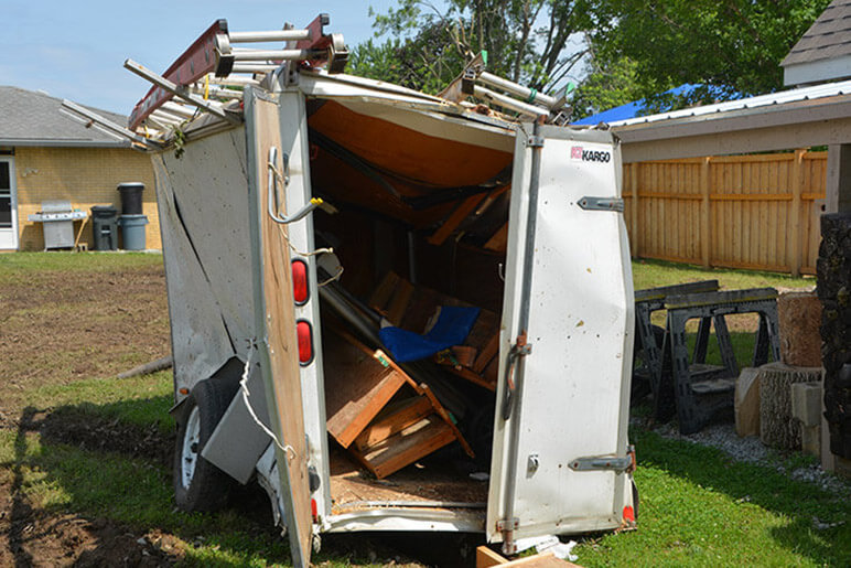 Photo of a destroyed trailer in someone's backyard