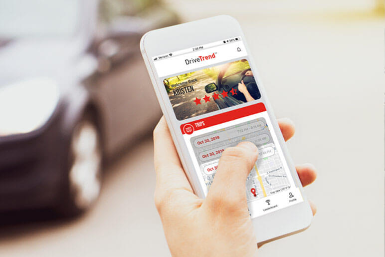 Hand holding a cellphone that has DriveTrend dashboard on the screen of the phone