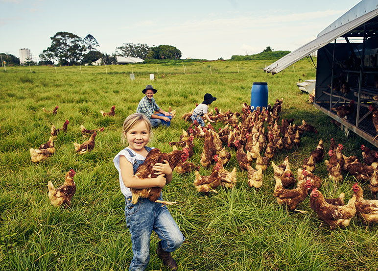 family outside in their farm with their chickens