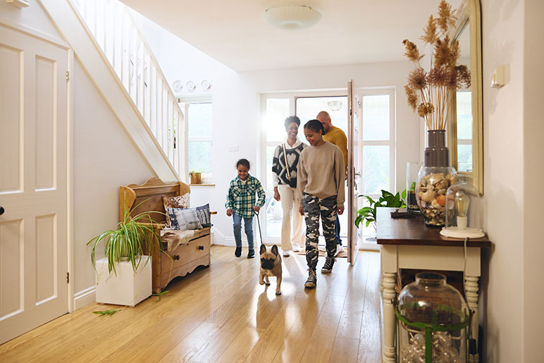 Family walking into a home thinking about does home insurance cover earthquake damage in Indiana?