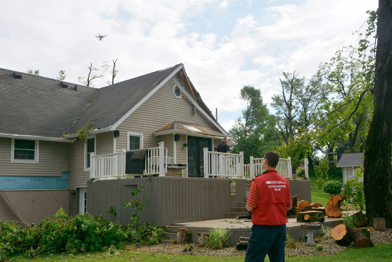 Indiana Farm bureau Insurance Claims Rep standing outside a storm damaged home