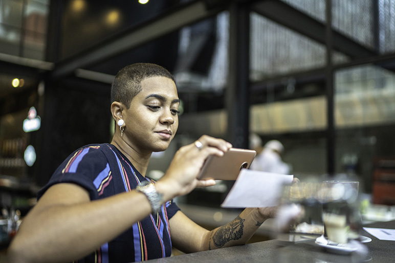 A woman deposits a check into her bank account virtually via her phone.