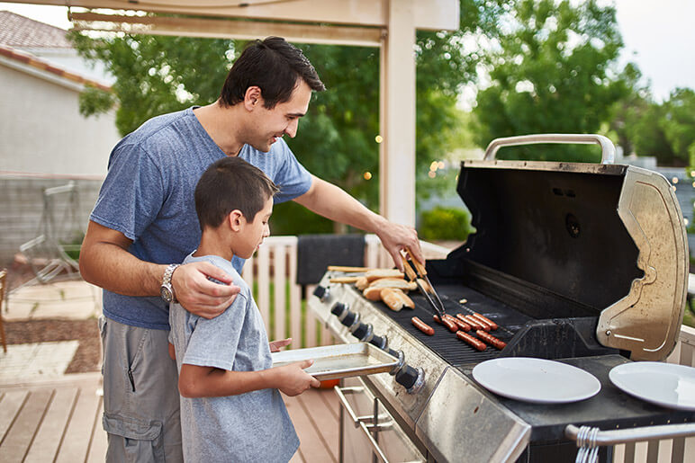 Dad and Son Grilling Hot Dogs