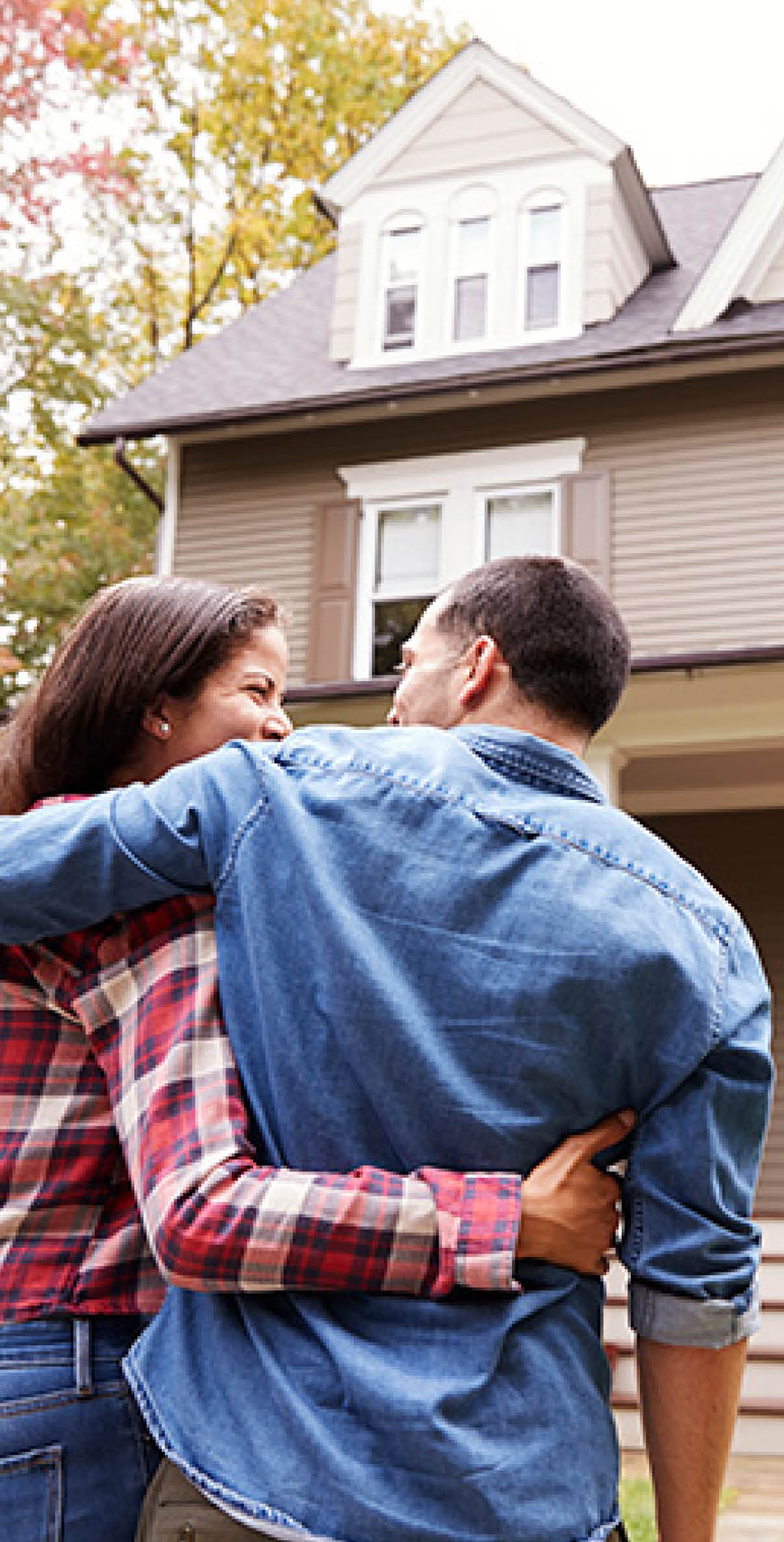 Happy couple walking up to their fully insured home.