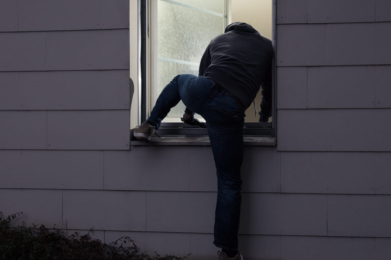 Burglar entering in the house from window