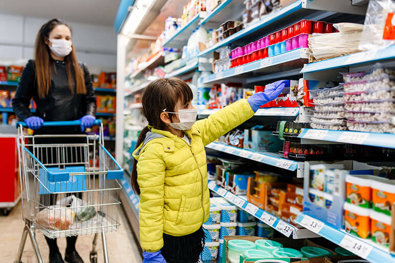 Mother and daughter at the grocery store with safety gloves and masks on