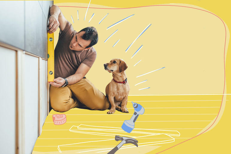 A man measuring something on his wall with his dog sitting next to him
