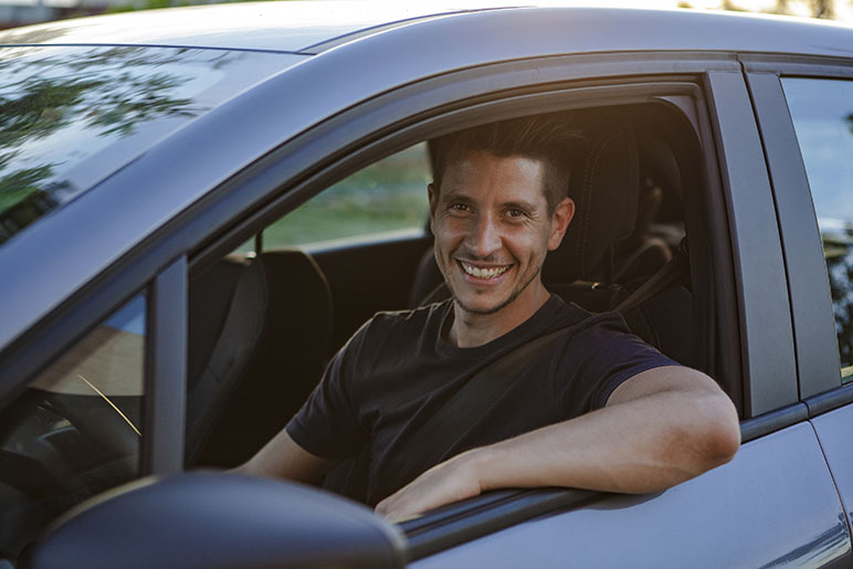 Man smiling out of his car