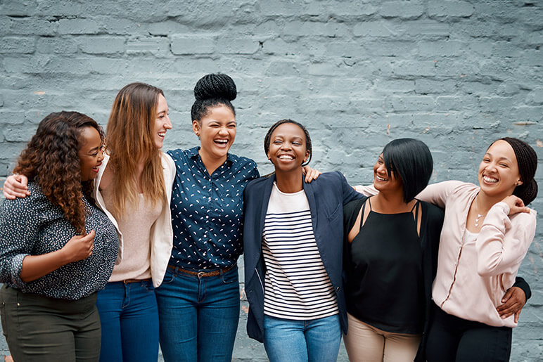 A group of 6 women laughing and smiling