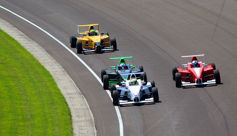 Photo of three racecars on the Indianapolis Motor Speedway during the Indianapolis 500