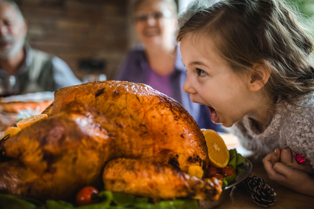 Little girl eating roasted turkey