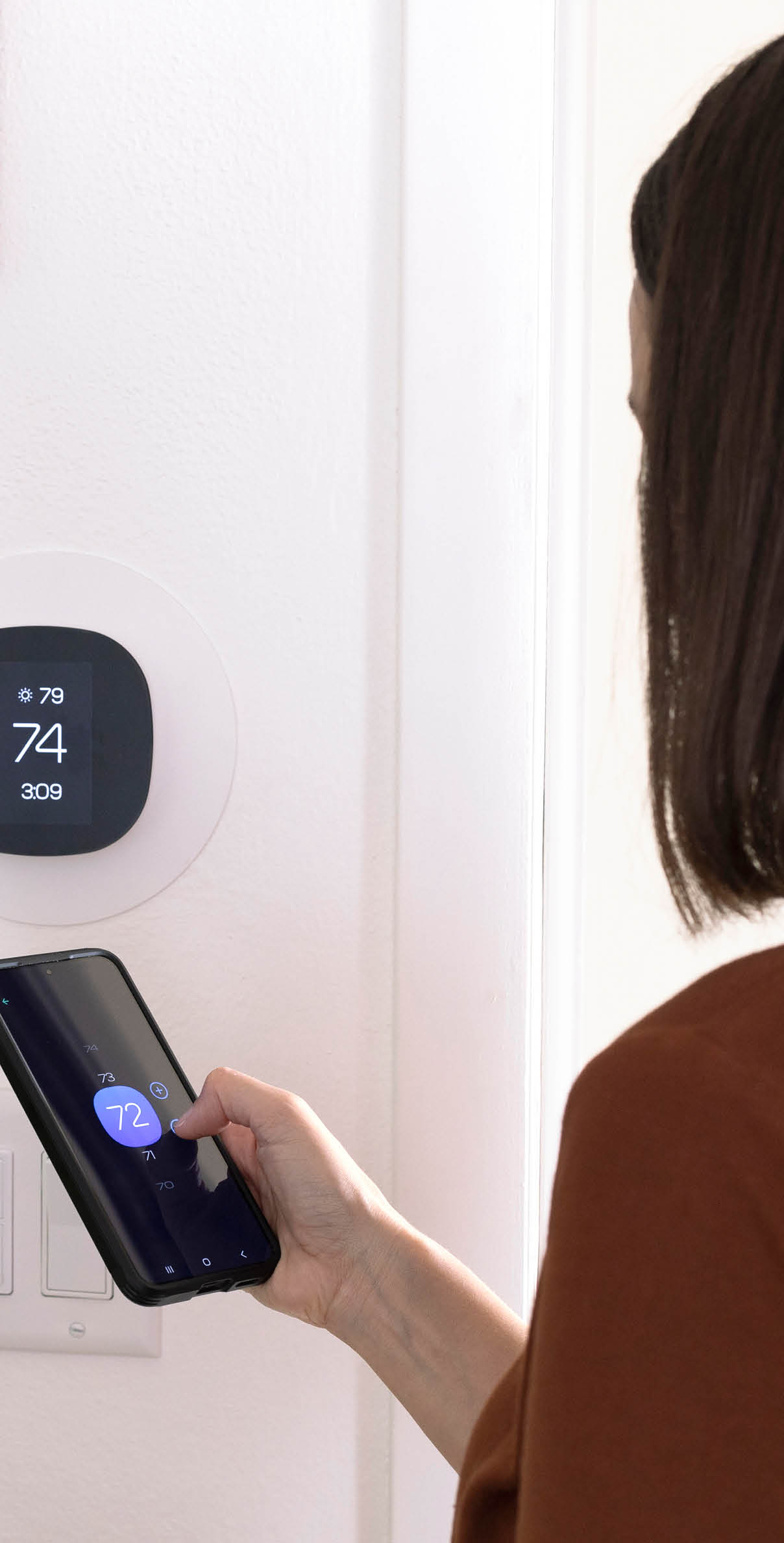 Woman programs her thermostat for AC efficiency 