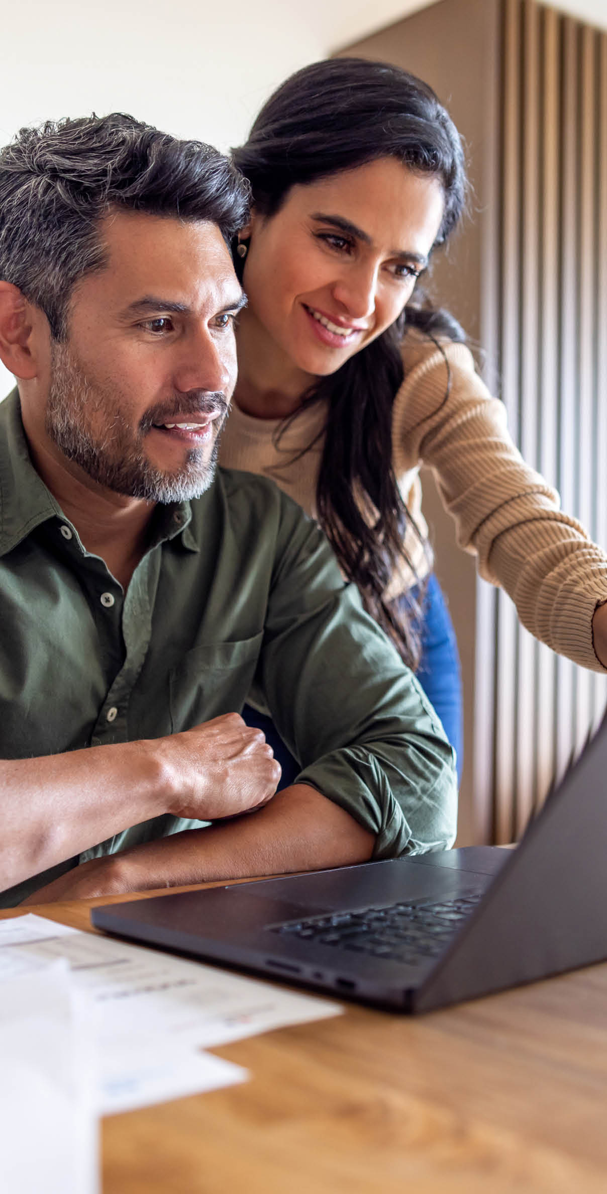 Couple looking at information on a laptop computer.