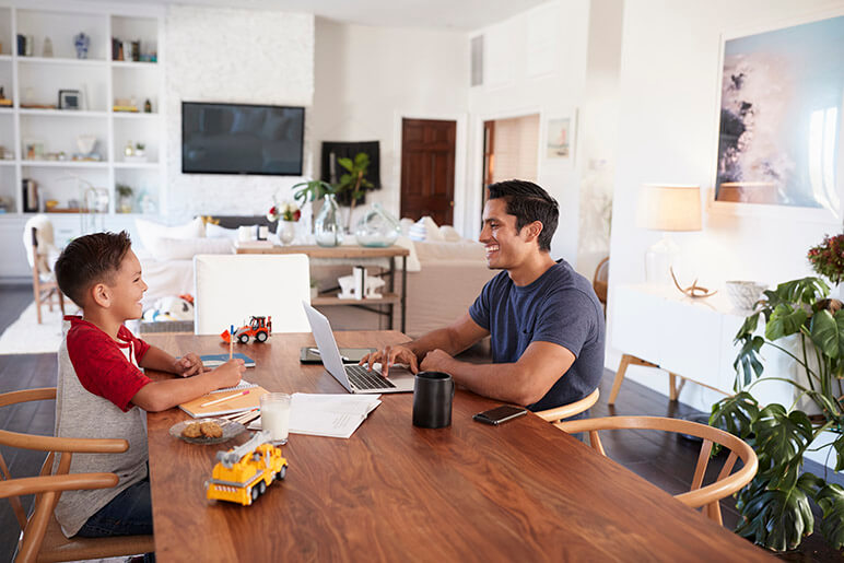 Father and son working from home at the table