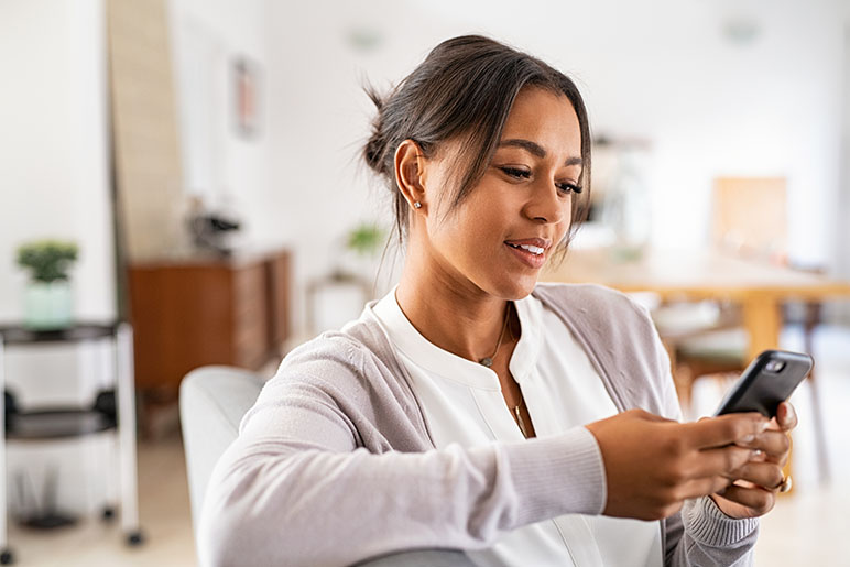 Young woman looking down at her phone