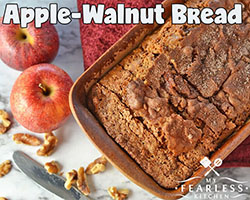 Warm fresh apple walnut bread in a pan next to other apples