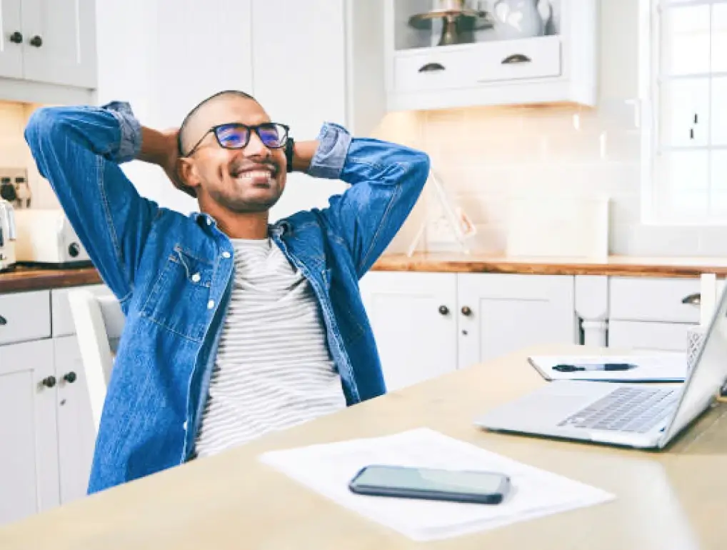 Men in blue jeans jacket and glasses reclining on chair happily after bundling his insurance and get discounted rates